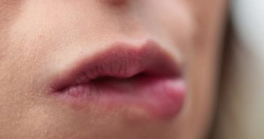 Dudaklarını ısıran genç bir kadının makro yakın çekimi.