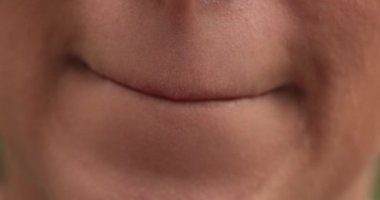 Kadının konuşmak istemeyen dudaklarının yakın çekimi. Konuşmasını tutan genç bir kadın. baskı dudakları