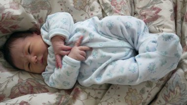 Yeni doğmuş bebek, hayatının ilk haftası boyunca bebek açısından dünyaya yukarıdan bakarak yatağa uzandı.