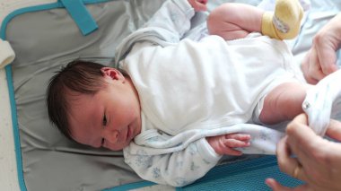 Anne onu giydirirken yeni doğan bebek gözlemciliği, bebek bakış açısı, hayatın ilk günlerinde bebek giydirme