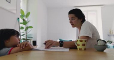Anne oğlunu masa başında eğitmeye çalışıyor. Parlak ve havadar bir yaşam alanındaki eğitim faaliyetlerine odaklanıyor.