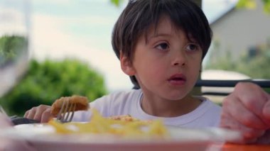 Küçük tatlı çocuk kafede patates ve nugget yiyor.
