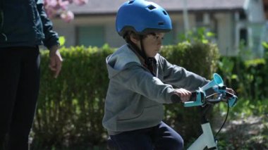 Bahar parkında bisiklet süren sevimli küçük çocuk.