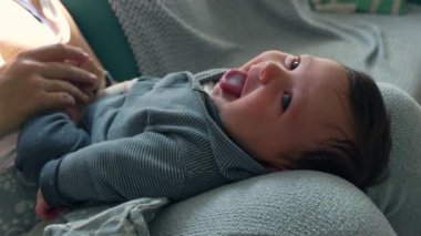 Sıcak bir yüzeyde uzanmış, kameraya gülümseyen mutlu bir bebek. Yakın plan, neşeli masumiyeti ve neşeli havayı yakalar, evdeki sıcaklığı ve aşkı ön plana çıkarır.