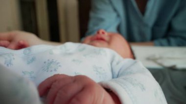 Yumuşak, küçük parmaklarıyla yeni doğmuş bir bebeğin elinin yakın çekimi, erken yaşamın narin ve hassas doğasını yakalıyor. Bebekliğin kırılganlığı ve güzelliği