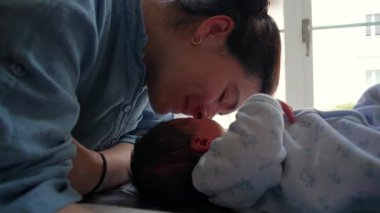 Anne, yeni doğan bebeğine nazikçe dokunarak samimi ve hassas bir an yaratıyor. Sahne, anneliğin ilk aşamalarında paylaşılan derin bağları ve sevgiyi yakalar.