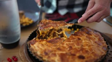 Bir dilim ev yapımı lezzetli turta keserek, lezzetli bir parça doğranmış tavuk, mısır ve sebzeyi ortaya çıkararak, sıcak, ev yapımı bir ortamda zengin dokuları ve altın kabuğu yakalıyor.