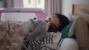 Anne ve yeni doğan bebek birlikte kestiriyorlar. Bebek göğsünde huzur içinde yatıyor. Huzurlu ve sevgi dolu bir yuva ortamında anne sevgisini yansıtıyor.