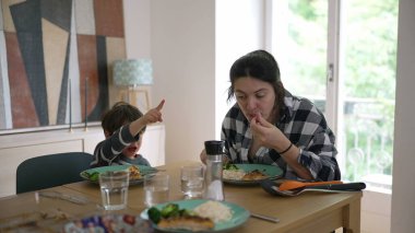 Anne ve küçük oğlu evde birlikte öğle yemeği yiyor, samimi bir aile yemeği yiyor, günlük hayatı gösteriyor, sağlıklı beslenme alışkanlıkları sergiliyor ve anne ile çocuk arasındaki bağ paylaşılan yemeklerde ortaya çıkıyor.