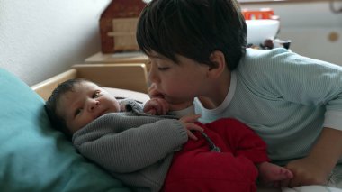 Büyük kardeş yeni doğmuş bir bebeğe sarılıyor. Yürek ısıtan bir kardeş sevgisi ve bağ kurma anı yaratıyor. Evdeki sevgi dolu aile ortamını yansıtıyor.