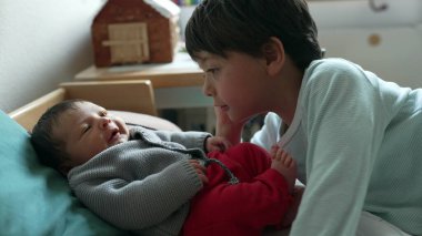 Büyük kardeş yeni doğmuş bir bebeğe sarılıyor. Yürek ısıtan bir kardeş sevgisi ve bağ kurma anı yaratıyor. Evdeki sevgi dolu aile ortamını yansıtıyor.