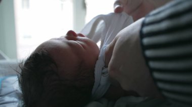 Yeni doğmuş bir bebeğin, bir yetişkin tarafından dikkatlice giydirilip hassas bir ebeveynlik anında gösterilen özen ve ilgiye dikkat edilmesi.