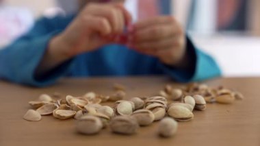 Çocuğun elleri masada fıstıklara uzanıyor, basit bir oyun ve keşfe odaklanıyor.