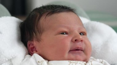 Yeni doğan bebeğin yakın plan portresi erken yaşlarda sıcak ve güvenli bir anı yakalıyor.