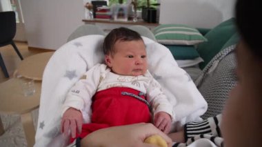 Yeni doğan bebeğin yakın plan portresi erken yaşlarda sıcak ve güvenli bir anı yakalıyor.