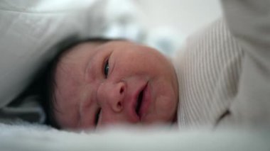 Yeni doğan bebeğin yakın plan portresi erken yaşlarda sıcak ve güvenli bir anı yakalıyor.