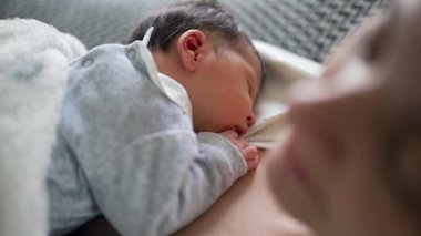 Yeni doğan bebek anne göğsünde huzur içinde uyuyor, yakın çekim görüntüsü, anne ve çocuk arasında paylaşılan rahatlık, güvenlik ve huzur dolu bağın altını çiziyor.