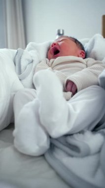 Yumuşak giysiler içinde yeni doğmuş bebek, sabah erken saatlerde ya da uykulu titreşimler ifade ederek, rahat battaniyeler, konfor ve sükunet ile ev ortamında, nazik yeni doğan an