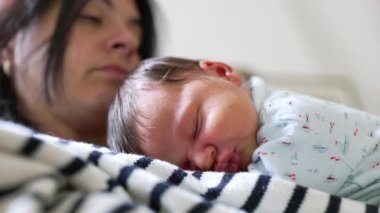 Anne ve yeni doğan birlikte uyuyorlar. Huzurlu ve sevgi dolu bir sahne yaratıyorlar. Güçlü bağı, sıcaklığı ve rahatlığı vurguluyorlar.