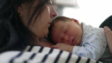 Anneye yakın çekim, yeni doğan bebek, hassas ve samimi bağ, anne ve bebek arasındaki huzurlu ve huzurlu bağı vurguluyor, yumuşak odaklanma, sıcak ışık