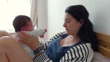 Anne yeni doğmuş bebeği kucağında tutuyor, hassas bir bağ ve bağ kurma anı yaşıyor. Samimi sahneler, erken annelik gösterileri için mükemmel besleyici bir çevredeki sıcaklık ve aşkı ön plana çıkarır.