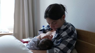 Anne bebeğini emzirirken rahatsızlık hissediyor, emzirmenin zorluklarını ve gerçeklerini kavrıyor ve annelerin çocuklarını büyütmedeki güç ve kararlılığını vurguluyor.