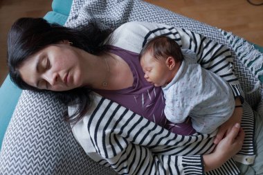 Bebeğin annesinin göğsünde huzurlu bir şekilde uyuması, sıcak ve rahat bir ortamda güvenlik ve aşkın özünü yakalaması. İkisi de rahat ve rahat. 