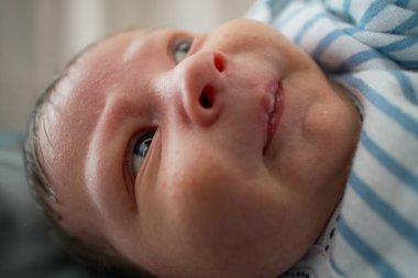 Mavi gözlü, yeni doğmuş bir bebeğin yüzünün aşırı yakın plan çekimi, ilginç bir ifadeyle, çocukluk döneminin masumiyetini ve mucizesini detaylı ve samimi bir perspektifle yakalıyor..