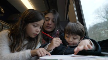 Anne ve çocuklar bir eğitim gezisinde, eğitimsel bir etkinlikle bir anı paylaşıyor, aile birlikteliğini ön plana çıkarıyor ve seyahat sırasında öğrenmenin keyfi, sıcak kış sahnesi