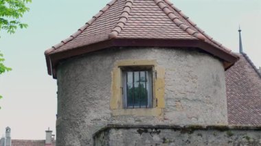 Ortaçağ şatosunda demir parmaklıklı bir penceresi olan eski taş kule, tarihi mimari sergiliyor ve huzurlu bir ortamda antik Avrupa tahkimatlarının kırsal cazibesini sergiliyor.