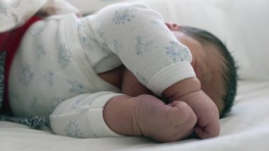Yeni doğan bebek kıvrılıp uyuyor. Rahat ve güvenli bir ortamda çocukluğunun huzurunu ve huzurunu vurguluyor.