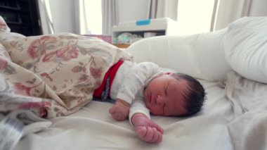 Yeni doğmuş bebek, yumuşak battaniyeler ve yumuşak ışıklarla çevrili bir yatakta huzur içinde uyuyor. Çocukluğunda huzurlu bir anı yakalıyor.