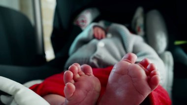 Relaxed baby in car seat, focus on tiny feet, soft and tender toes, cozy and calm atmosphere, detailed view of newborn's feet, intimate and peaceful moment of rest, comfortable and serene  clipart