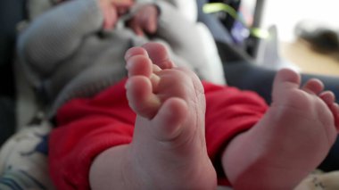 Relaxed baby in car seat, focus on tiny feet, soft and delicate toes, cozy and calm atmosphere, detailed view of newborns feet, intimate and peaceful moment of rest, comfortable and serene  clipart