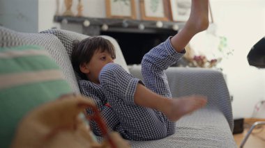 Genç çocuk, çocukluğun masumiyetini ve neşesini vurgulayarak rahat bir yuva ortamında eğlenceli ve kaygısız bir atmosfer yaratıyor.