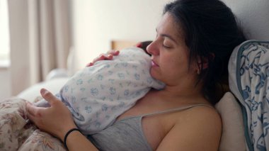 Anne göğsünde yeni doğmuş bir bebekle, gözleri kapalı, huzurlu ve rahatlatıcı bir kucaklaşmayla anne ve çocuk arasındaki derin bağı ve sevgiyi sessizce yansıtıyor.