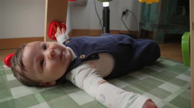 Bir bebeğin paspasın üzerinde yatarken, rahat olmayan bir ortamda kollarını açarak ağlamasının tüm vücudu. Bebek doğal ışıkta sıkıntı ve hayal kırıklığını ifade eder.