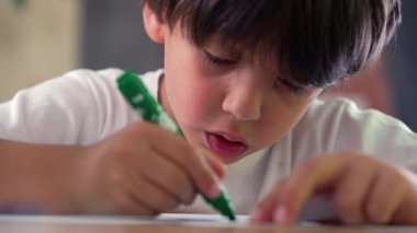 Yeşil kalemle boyama, dikkatle çizim, odaklanma ve sanatsal sürece sessiz bir ev ortamında katılım.