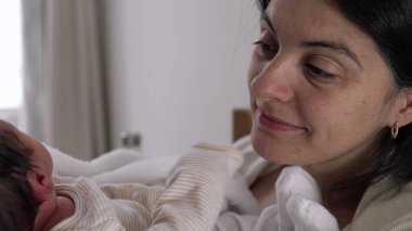 Annesinin yeni doğmuş bebeğini kucağında tutarken, birbirlerine sevgiyle bakarken, sıcaklığı, bağlantıyı ve şefkati aktarırken, samimi bir yuva kurarken, doğal gün ışığında.