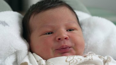 Yumuşak bir battaniyenin üzerinde dinlenen, şefkatli bir ev ortamında sıcaklığı ve mutluluğu yakalayan yeni doğmuş bebek.
