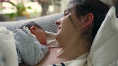 Yeni doğmuş bebeğiyle birlikte uzanmış, göğsünde huzur içinde uyuyan, sıcaklığı, güvenliği ve derin bağı yakalayan bir annenin yakın çekimi bu samimi ve hassas anda paylaşılır.