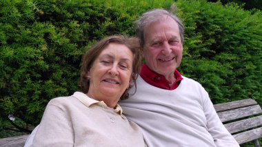 Yaşlı bir çift bankta oturuyor, kameraya gülümsüyor, bir park ortamında yemyeşil ile çevrili, uzun süreli ilişkilerinin sıcaklığını ve sevgisini sergiliyorlar.