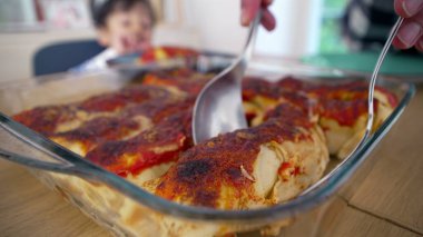 Taze pişmiş, yemek masasındaki cam bir tencerenin içinde ev yapımı enchiladalar servis edilmeye ve keyif almaya hazır.