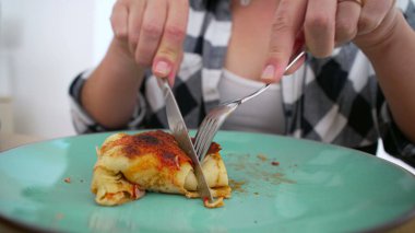 Kareli gömlekli biri yeşil tabakta ev yapımı enchilada servis ediyor. Lezzetli bir yemeğin tadını çıkarmaya hazır.