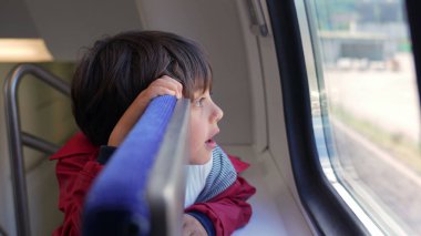 Young boy gazing out the train window, lost in thought, reflecting the curiosity and wonder of childhood during a journey, symbolizing exploration and the excitement of travel adventures clipart