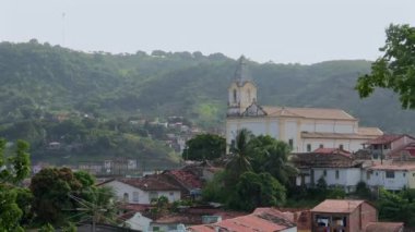 Salvador 'un tuhaf bir mahallesindeki tepelik bir arazinin ortasındaki tarihi bir kilisenin manzarası. Doğa ve mimarinin karışımı, Brezilya 'nın geleneksel şehir manzarasının güzelliğini gözler önüne seriyor.