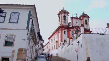 Ouro Preto 'da dar bir cadde, yolun sonunda tarihi bir kilise ve koloni mimarisi var. Dik yol ve klasik binalar kasabanın zengin kültür mirasını çağrıştırıyor.