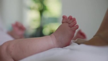 Küçük ayağıyla annesinin çenesine tutunan bir bebeğin yakın çekimi hassas ve eşsiz bir bağ kurma ve keşfetme anını gözler önüne seriyor.