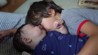 Ağabeyi bir kanepede bebek kardeşinin yanında yatarken sevgi dolu bir bağ ve şefkat anı yaşıyor. Her iki çocuk da sıcak bir ev ortamında sakin ve samimi bir zaman geçiriyor.