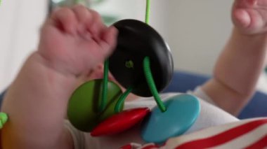 Bebek tutarken ve çekerken bir fedainin içinde yatarken, duyusal oyun ve motor becerilerini göstererek, sakin bir ev ortamında aktif olarak keşif yaparak,